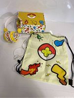 Kids headphones, themed drawstring bag, and box arranged on white surface