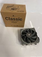 Box packaging of the Thermalight Classic AXP90-X47 CPU cooler and the cooler unit placed alongside it on a white surface.