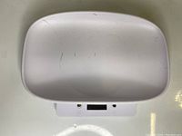 Top view of white plastic bowl integrated with digital kitchen scale, showing surface scratches on bowl.