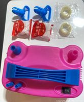 Top view of balloon pump accessories including clips, adhesive strips, and plastic rings arranged next to the pump.