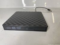 Front angled view of the external DVD/CD drive showing top textured pattern and USB cable.
