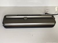 Front angle view of the food vacuum sealer showing the sealing strip and control buttons on the top panel.