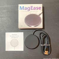 Photo of MagEase wireless charger box, charging pad, USB cable, and user manual laid out on a table.