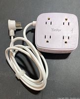 Top view of white power strip showing 8 sockets and USB ports with coiled white power cable and three-prong plug.