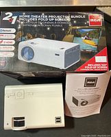 RCA home theater projector box, projector unit and instruction manual displayed.