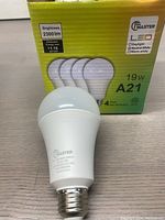 Photo of a pack of four Master brand 19W A21 LED light bulbs with one bulb out of the box showing bulb details and packaging indicating 2300 lumens brightness.