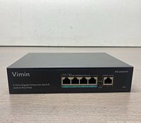 Front view of the black Vimin 5-Port Gigabit Ethernet Switch showing 4 PoE ports and 1 additional port with labels and indicators.
