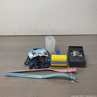 Full view of all items in the bundle including collars, leash, pet hair roller, GPS tracker in box, charging cable, and protective case.