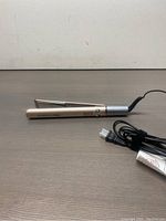 Furiden Pro 2-in-1 hair styling tool laid flat on surface, showing side profile with open plates and power cord.