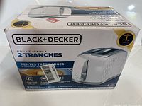 Image of Black & Decker toaster box front, showing product image and brand with 2-slice toaster and extra-wide slots features.