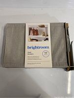 Photo of the Brightroom shelf divider folded with packaging label showing product name and image of usage on shelves.