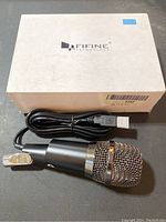 Fifine Technology branded box with USB condenser microphone placed on top, USB cable attached.