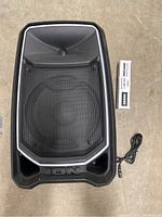 Full view of the Ion Total PA Freedom Bluetooth speaker showing its front with protective grille, Ion logo, and power cord attached.