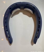 Front view of dark blue ergonomic neck fan showing fan vents and speed controls.