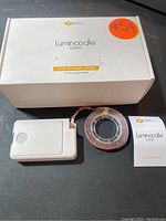Photo of one Luminoodle Click LED strip coiled next to a white battery pack and the product box with label 'Stick Anywhere Lighting 3-Pack Luminoodle Click'