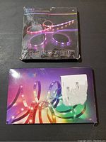 Two boxed RGB LED strip light sets from SINWE and Nexillium brands showing product images and packaging condition.