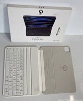 White Houd branded tablet keyboard case open with detachable Bluetooth keyboard displayed next to original packaging.