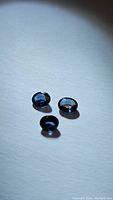 Three natural oval cut blue sapphires approx 5x4mm despite slight difference in lighting angle