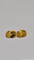 Front view of the yellow oval cut sapphire pair showing color and clarity.