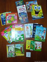 Multiple children's books including Dr. Seuss titles and others, arranged on a brown surface showing a variety of colorful covers.