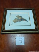 Front view of the framed chipmunk print by M. G. Loates on a wooden surface with auction lot number.