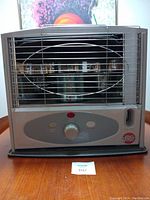 Front view of KeroWorld kerosene heater showing control panel, protective grill, and brand label.