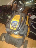 Yellow and black Cub Cadet lawnmower with 173cc 9HP engine visible on the engine cover, showing the mower's condition and branding.