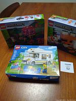 Three LEGO sets on table: two Minecraft sets behind one LEGO City Camper Van set.