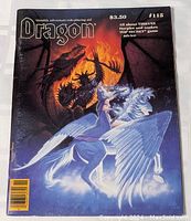 Front cover of Dragon Magazine Issue #115, showing a dragon and a figure riding a winged horse, priced at $3.50.