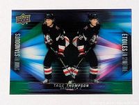 Front view of 2023-2024 Tage Thompson 3D insert hockey card showing player in black Buffalo Sabres jersey with mirrored 3D effect and colorful background, Upper Deck logo top left.