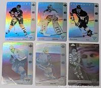 Six 3D foil holographic hockey cards displayed face up in a 2x3 grid, showcasing star players in action poses with rainbow foil backgrounds.