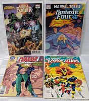 Top-down photo showing front covers of four comic books arranged in a square: Secret Wars Ghost Panther #1, Marvel Tales Fantastic Four #1, Justice League International, and The Uncanny X-Men and The Titans.