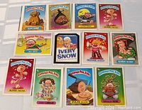 Group photo of 12 Garbage Pail Kids cards showing various character illustrations.