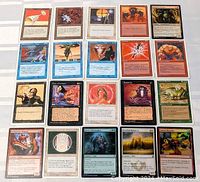 Photo of 20 Magic The Gathering cards laid out in a grid, showing various cards with different characters, colors, and card types including foil effects.