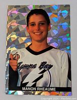Front of Manon Rheaume hockey card showing her smiling in Tampa Bay Lightning goalie jersey with holofoil geometric background.