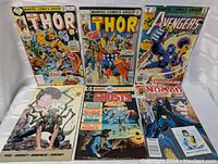Six comic books displayed showing front covers with various Marvel and DC titles including Thor, Avengers, Nomad, Ghosts and The Twist.
