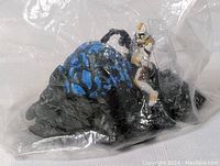 Star Wars clone trooper toy model in clear plastic packaging on detailed black and blue base, showing figure standing on terrain.