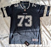 Front full view of the navy blue Dallas Cowboys NFL jersey with number 73 and tags visible.