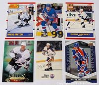 Top-down image of six Wayne Gretzky hockey cards laid out flat, showing front of each card with different team uniforms and series titles visible.