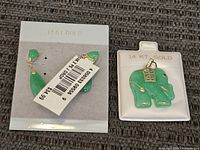 Close-up of one earring showing teardrop and pear-shaped green stones