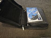 Binder open showing a clear sleeve with 1080° Avalanche game disc and instruction booklet.