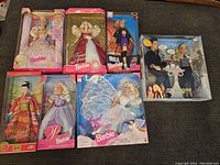 Lot showing all seven dolls in original boxes arranged on couch