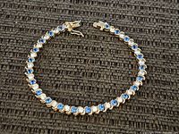 Full view of the bracelet laid in a slight curve showing the overall design and clasp