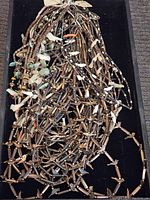 Multiple Southwestern style necklaces made with brown heishi beads, featuring fetish pendants in turquoise, shell, coral, and stone carved in animal shapes.