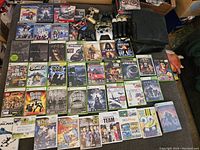 First image shows consoles, controllers and microphones arranged on floor with game cases above.