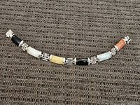 Full view of the Asian-style sterling silver bracelet showing multiple colored stone inlays and geometric silver connectors.