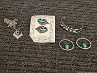 Full lot showing a pendant necklace, cuff bracelet, two pairs of earrings, and a packaged earring set