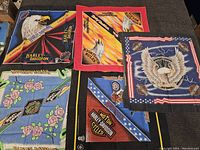 Five vintage Harley Davidson bandanas laid out showing different designs including eagles, roses, Harley Davidson logos, and American flag motifs.