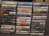 Photo of stacked vintage rock cassette tapes showing various artists and titles.