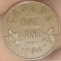 Reverse side of the 1934 Canadian One Cent coin showing denomination, maple leaves, and date